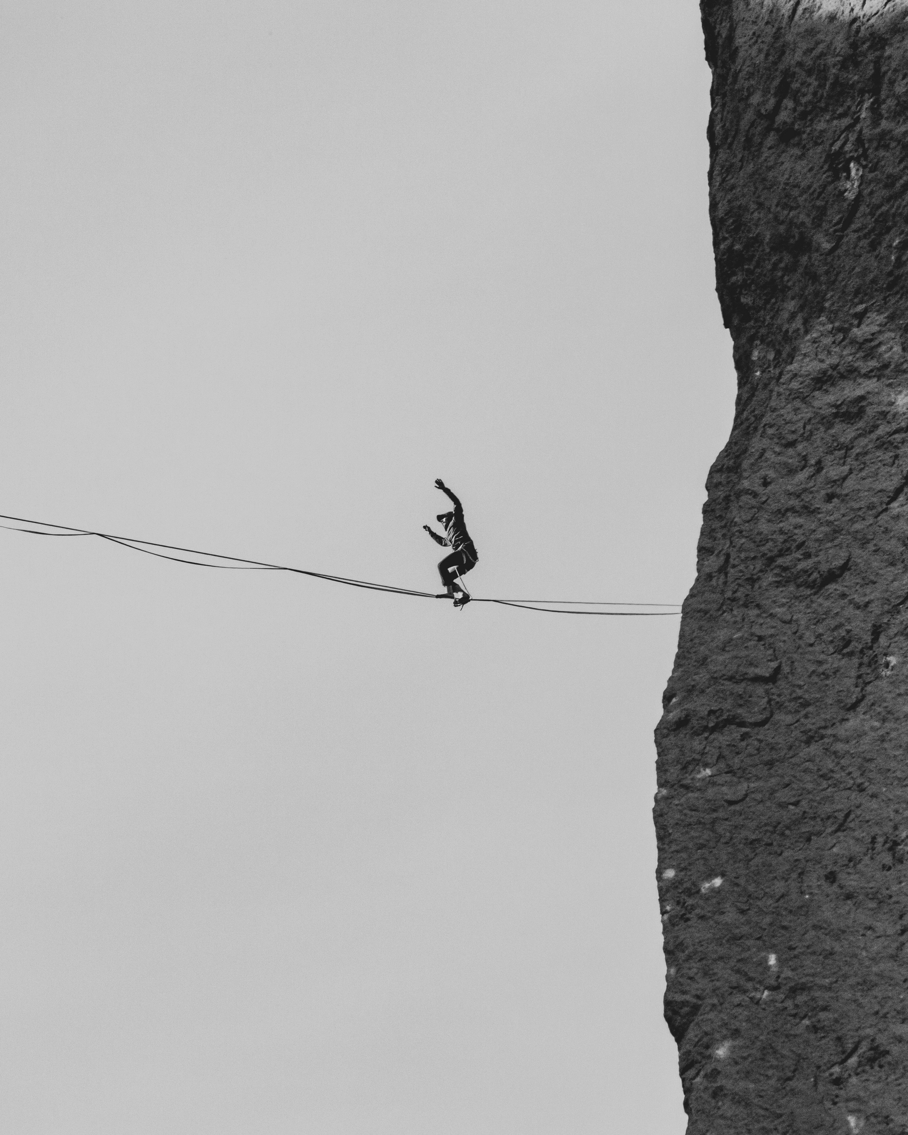An image of a man walking on a thin line, having the chance of falling off any time. But no worries, there is Dify Help. 